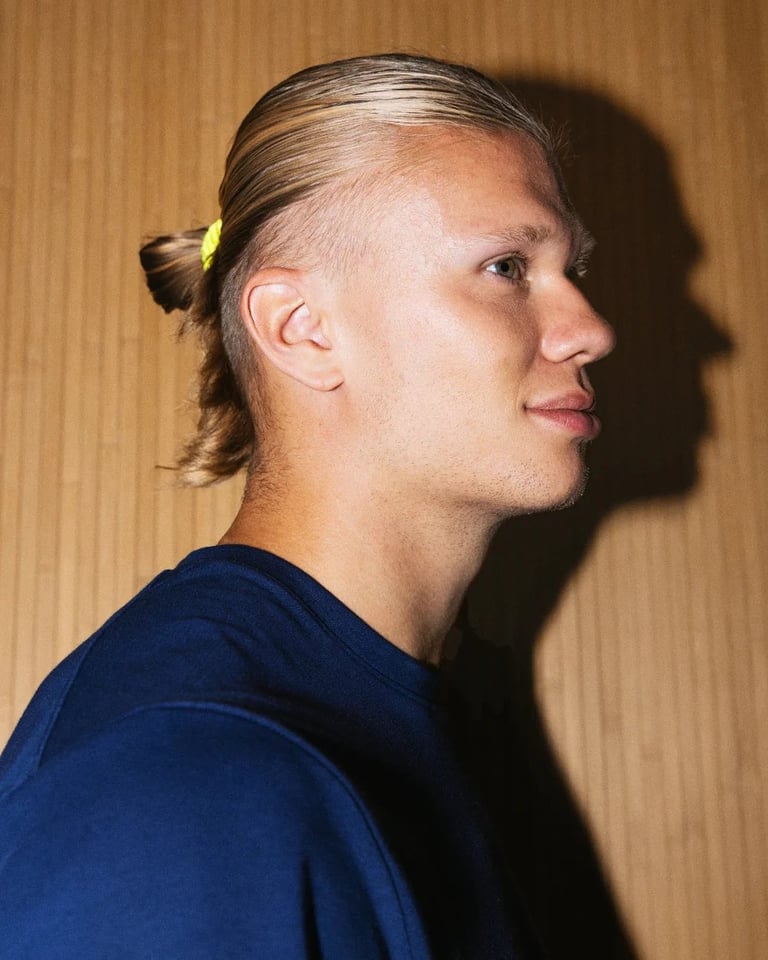 Person in profile view wearing a dark blue shirt against a wood-textured background