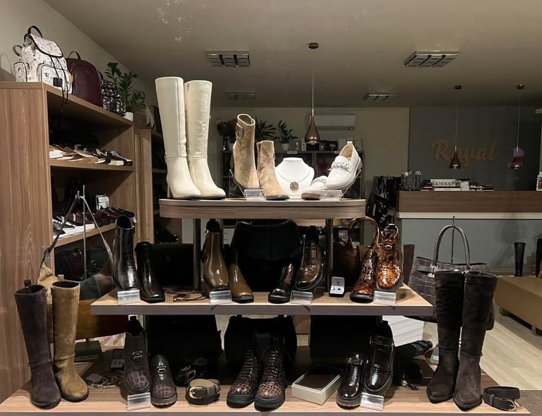 Retail shoe store display featuring multiple black and white boots and heels arranged on shelves and stands