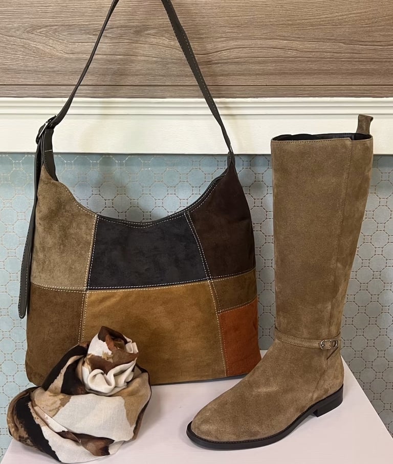Patchwork suede shoulder bag in brown tones with matching tall suede boots and cream scarf displayed together