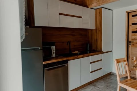 Modern kitchen with white cabinetry, wooden accents, stainless steel appliances, and wooden counter workspace