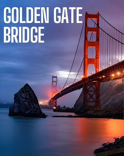 Golden Gate Bridge at sunset with illuminated cables and towers, rocky outcrop in foreground, calm blue and orange waters below
