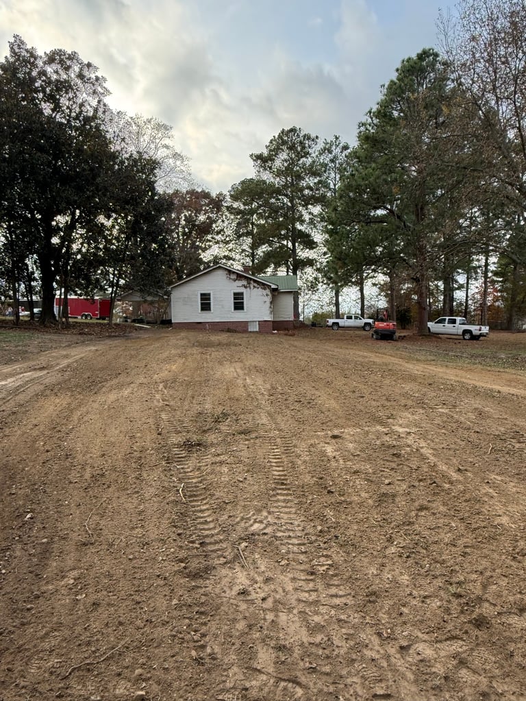 Finished residential site with a house on a graded dirt driveway