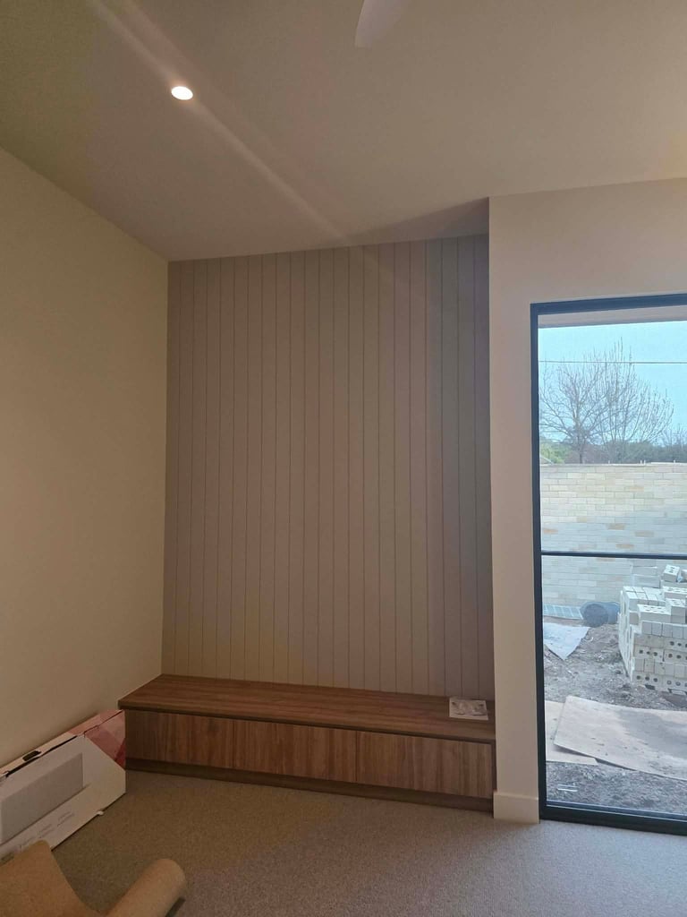 Interior room with vertical wood paneling on wall, wooden bench seat, glass door with outdoor view, and recessed ceiling light