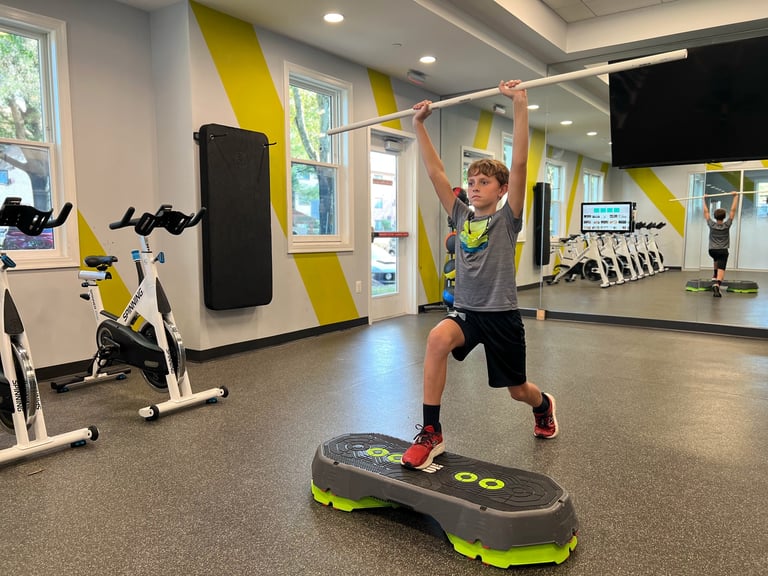Young athlete doing step aerobics exercise on a platform in a modern gym