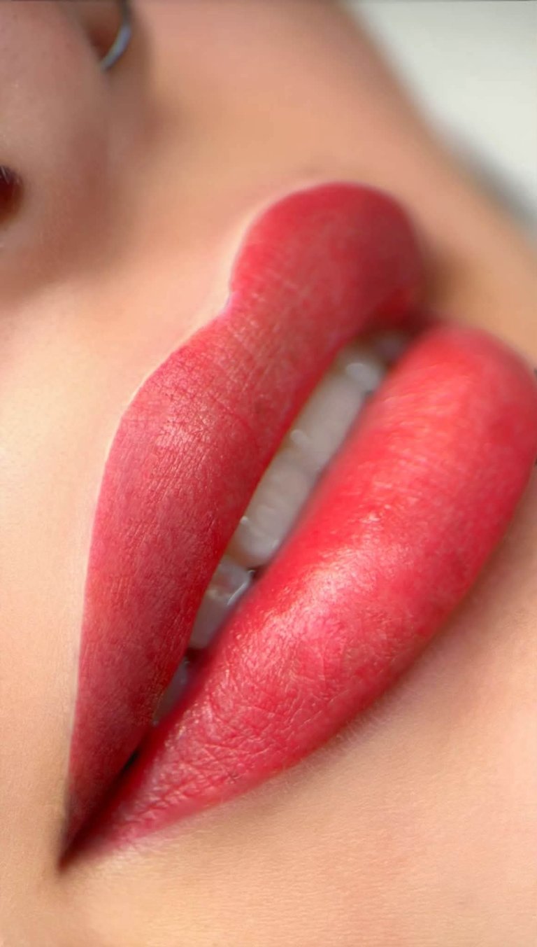 Close-up of lips wearing bold red lipstick with a matte finish