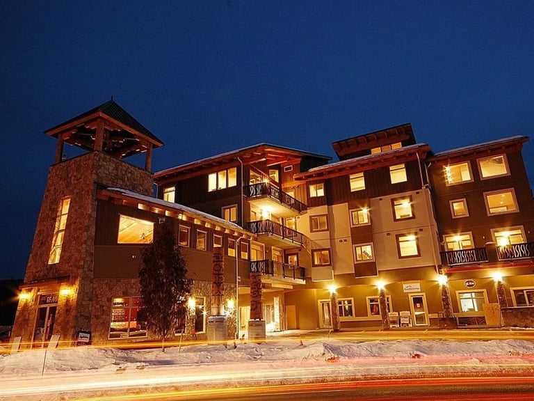 Historic brick building complex at dusk in alpine setting, representing complex property and development projects in sensitive environments