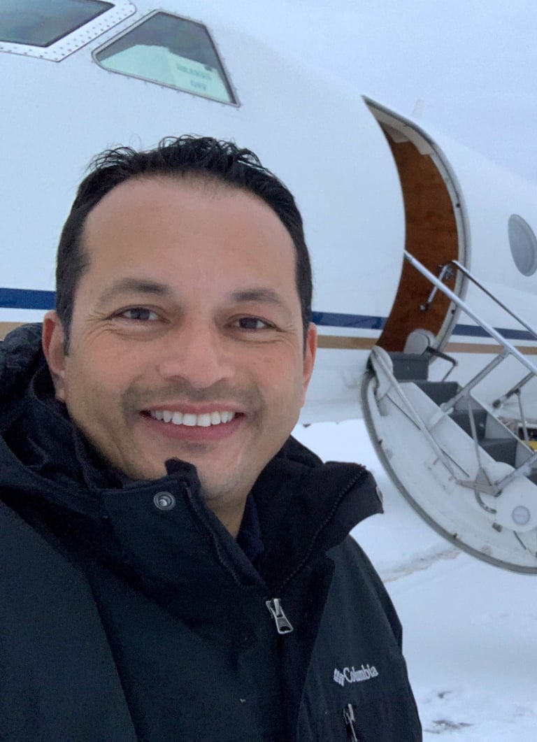 Francisco Barrios, founder of Corporate Flight Ops, in front of a private jet on a snowy tarmac