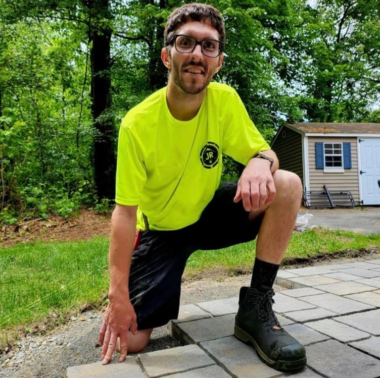 Owner in JR safety shirt working on stone patio in front yard