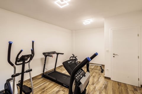 Home gym with treadmill, stationary bike, and elliptical machine