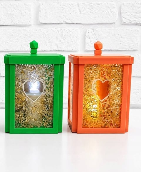 Zielony i pomarańczowy drewniany lampion z sercem — wypełniony suszonymi kwiatami w złotym świetle