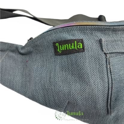 Close-up of gray fabric Lunula waist bag with green logo label and black adjustable straps