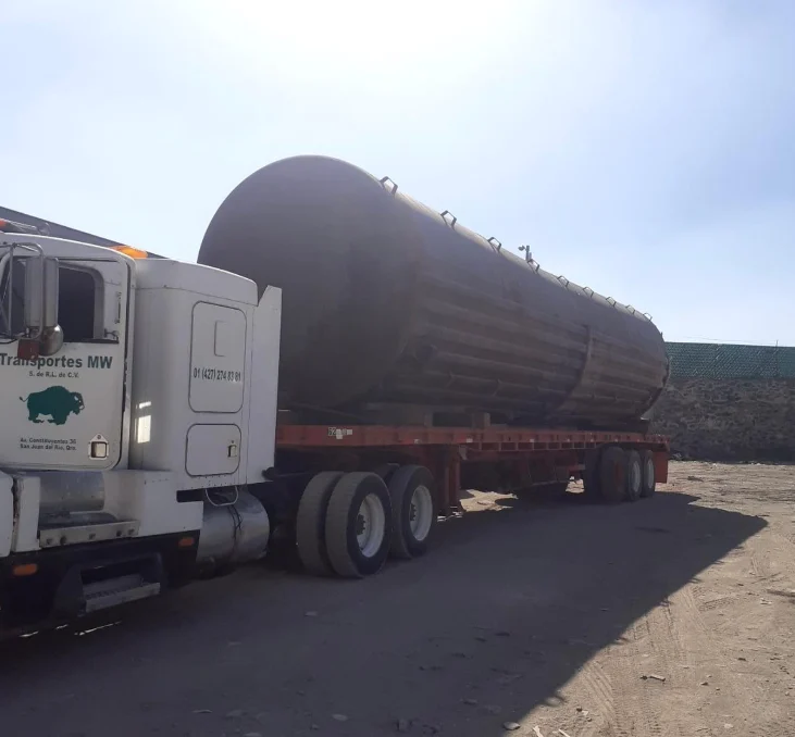 Transportes MW con pipa de carga cilíndrica en patio industrial