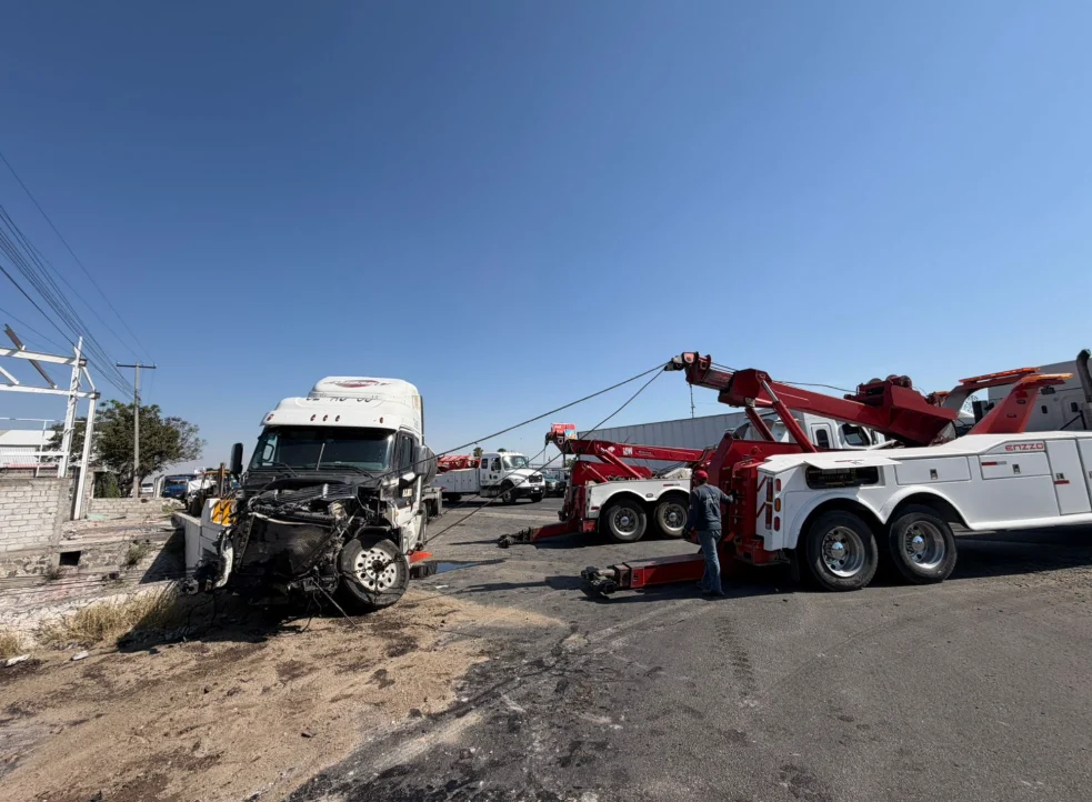 Grúa pesada MW recuperando tracto Freightliner siniestrado con pluma