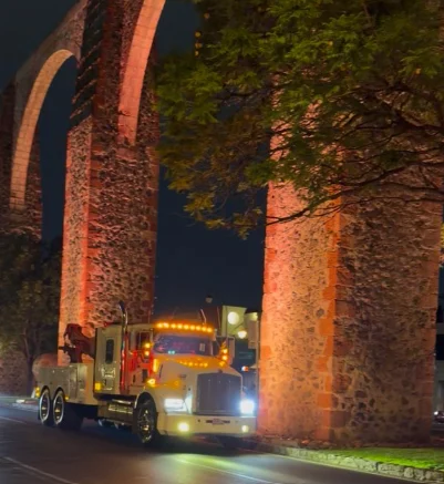 Camión de GRUPO MW bajo los arcos de piedra iluminados de noche