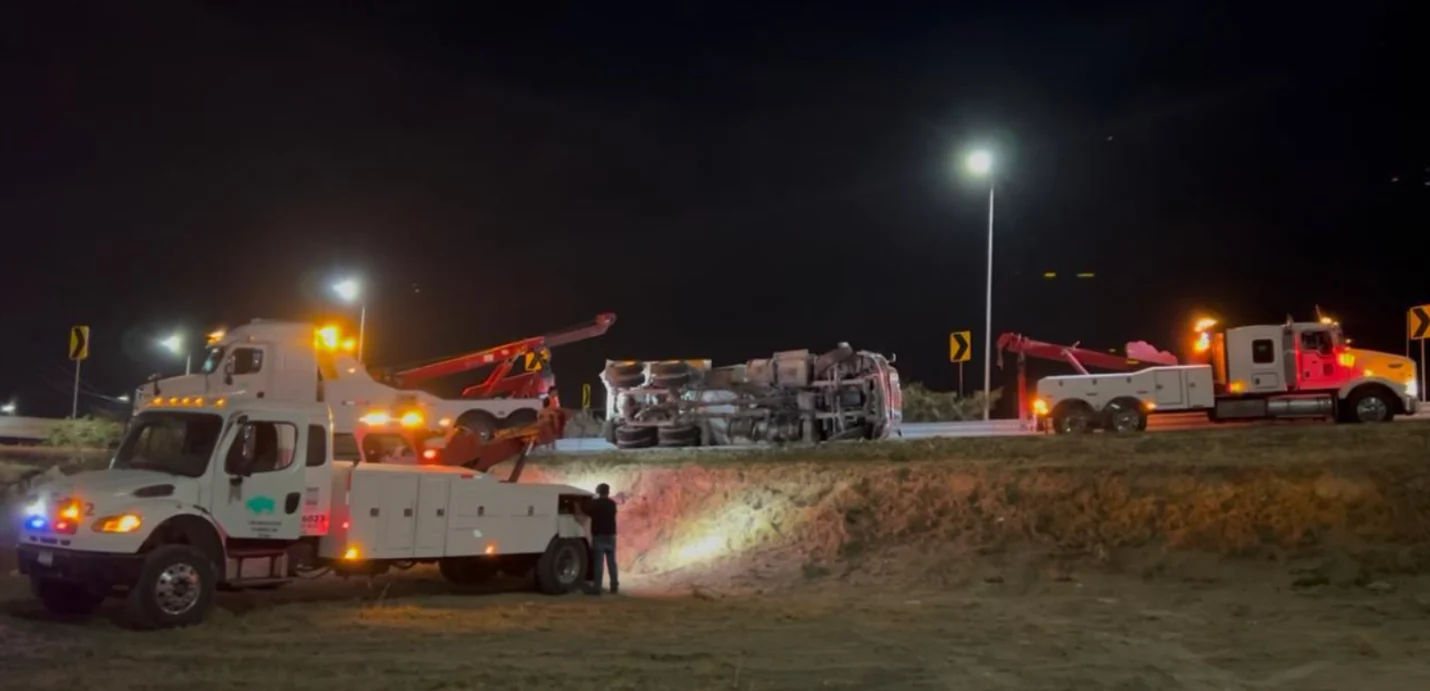 Unidades de GRUPO MW con luces de emergencia trabajando de noche en rescate de trailer volcado