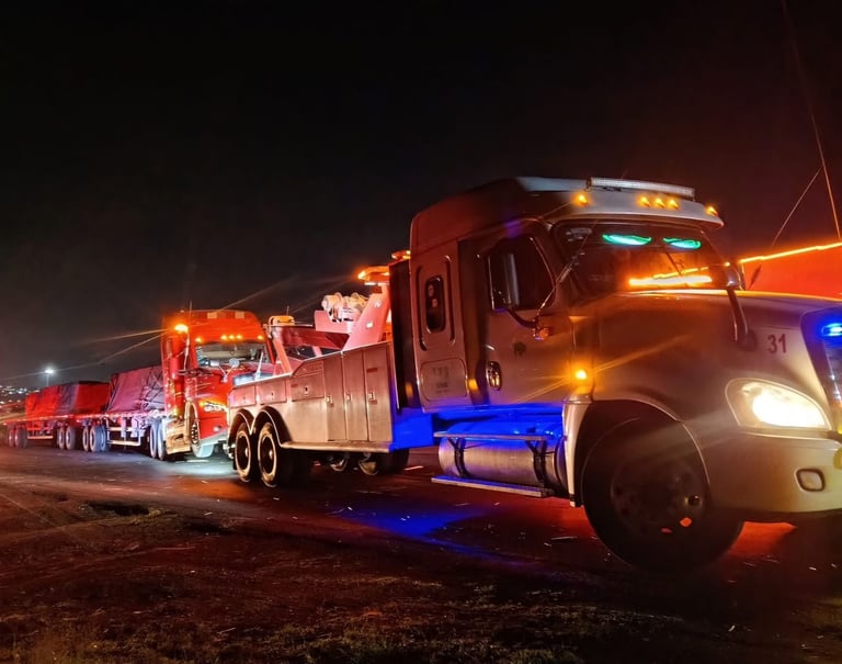 Vehículos de emergencia iluminados de noche con grúas y equipo de rescate