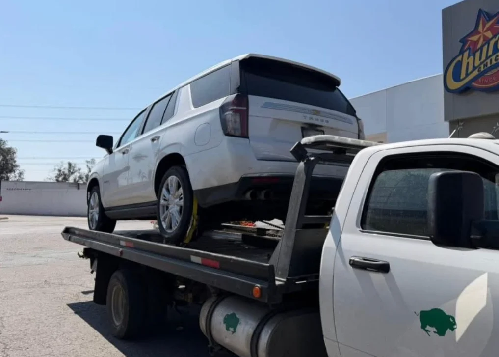 Grúa ligera MW con plataforma trasladando Suburban blanca