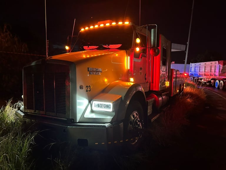 Tractocamión con luces ámbar encendido en operación nocturna
