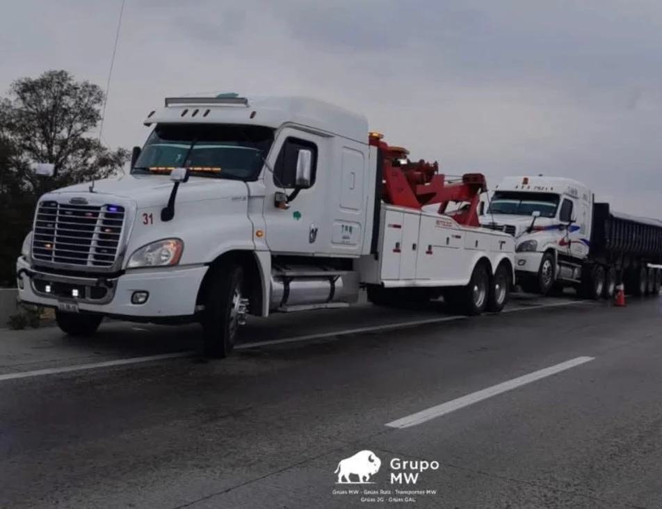 Convoy GRUPO MW en carretera: grúa pesada unidad 31 con pluma y tracto Freightliner