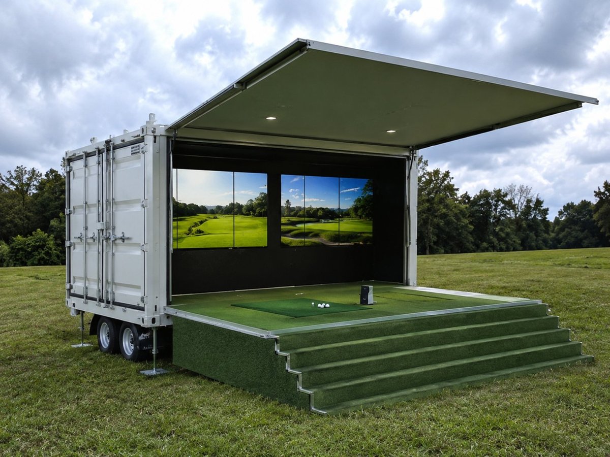 Green shipping container transformed into an outdoor event space with extended canopy and golf simulator screens in grassy field