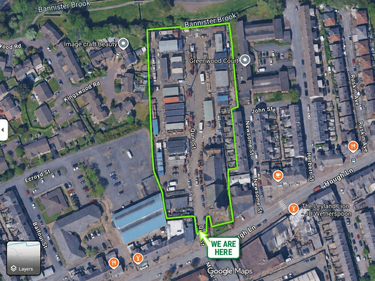 Aerial satellite map view of an industrial area with buildings, parking lots, and a green outlined property boundary with location markers