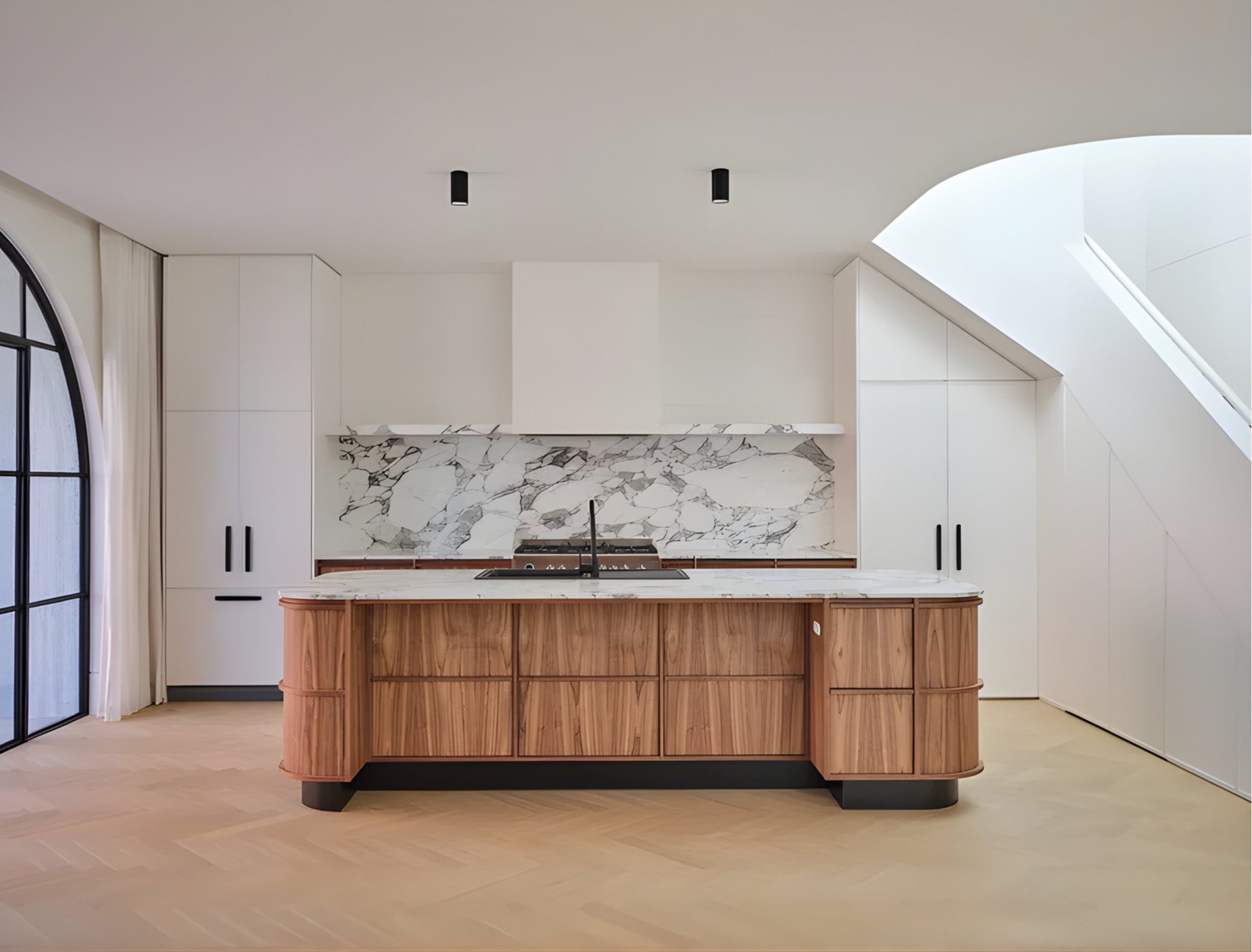 Modern kitchen with large wooden island, marble backsplash, white cabinetry, and minimalist design in bright, open space