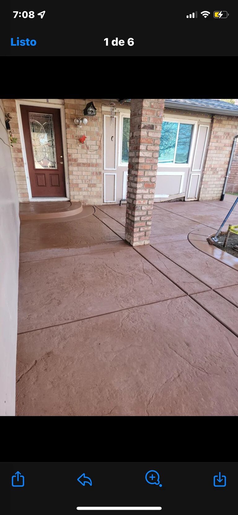 Brick house entryway with stamped concrete patio and red front door