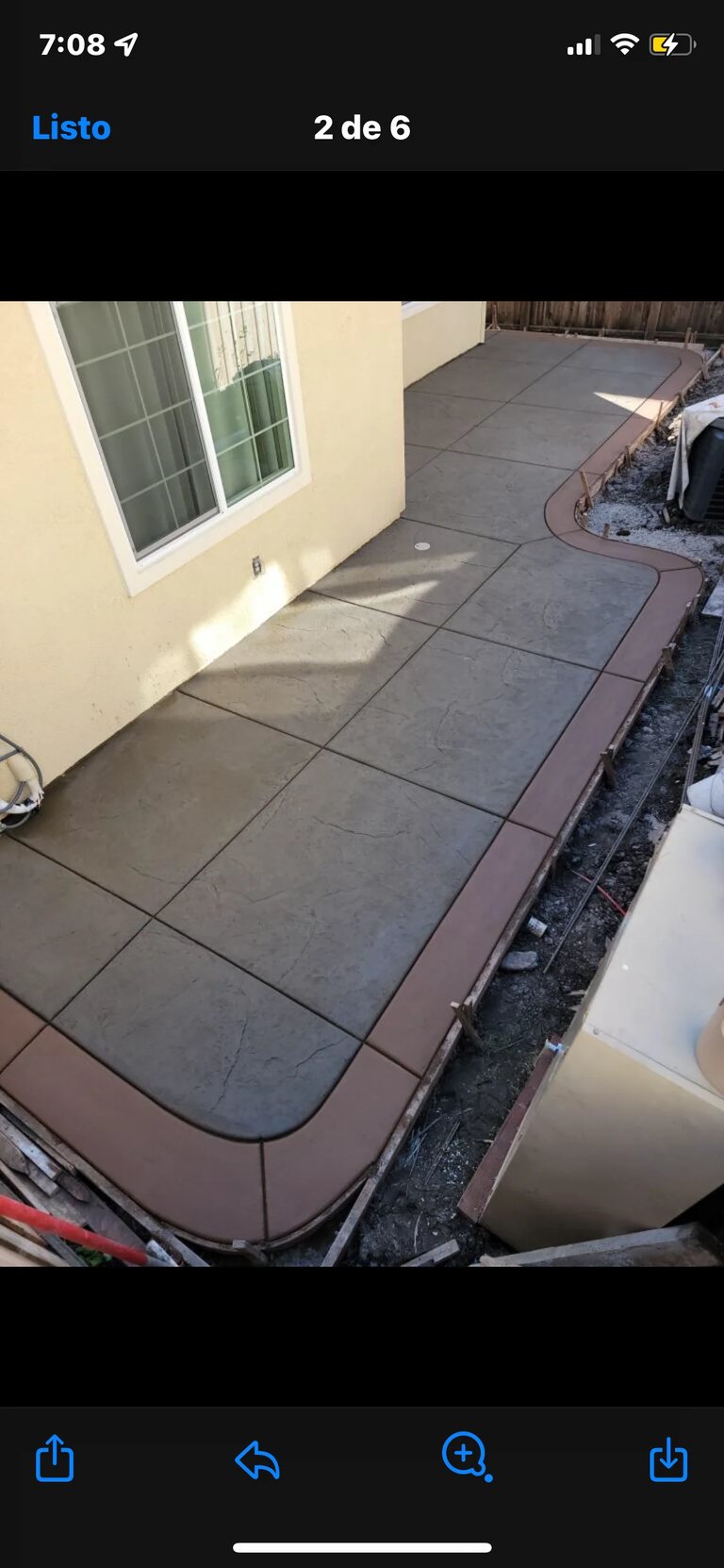 Stamped concrete patio pathway alongside a cream-colored house