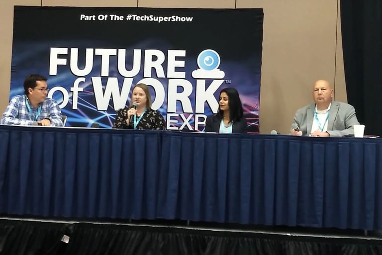 Panel discussion at the Future of Work Expo with speakers seated at a table