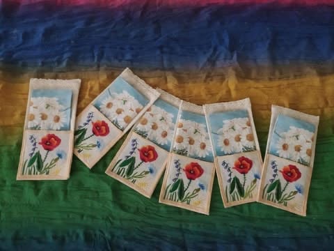 Siedem zakładek do książek z czerwonymi kwiatami na kolorowym pasiastym tle