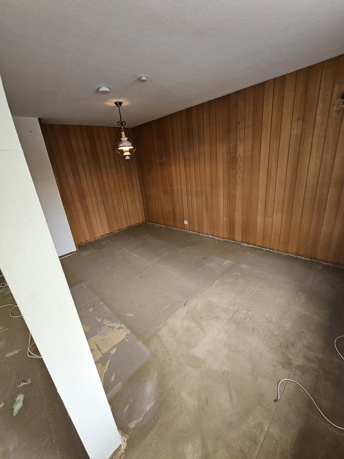 Vollständig geräumtes leeres Zimmer mit Holzwandvertäfelung nach der Entrümpelung — M☆K König Augsburg