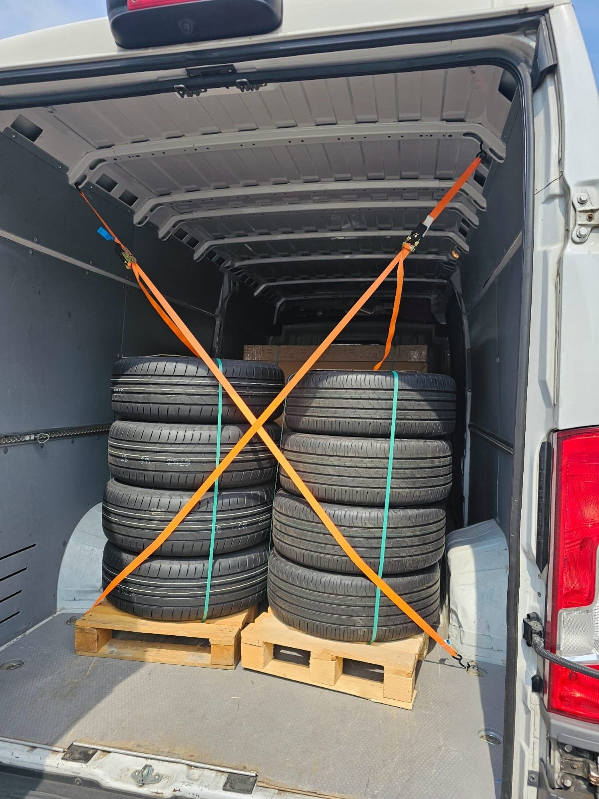 Autoreifen auf Paletten im Transporter, mit orangen Gurten fachgerecht gesichert — M☆K König Möbeltransport Augsburg