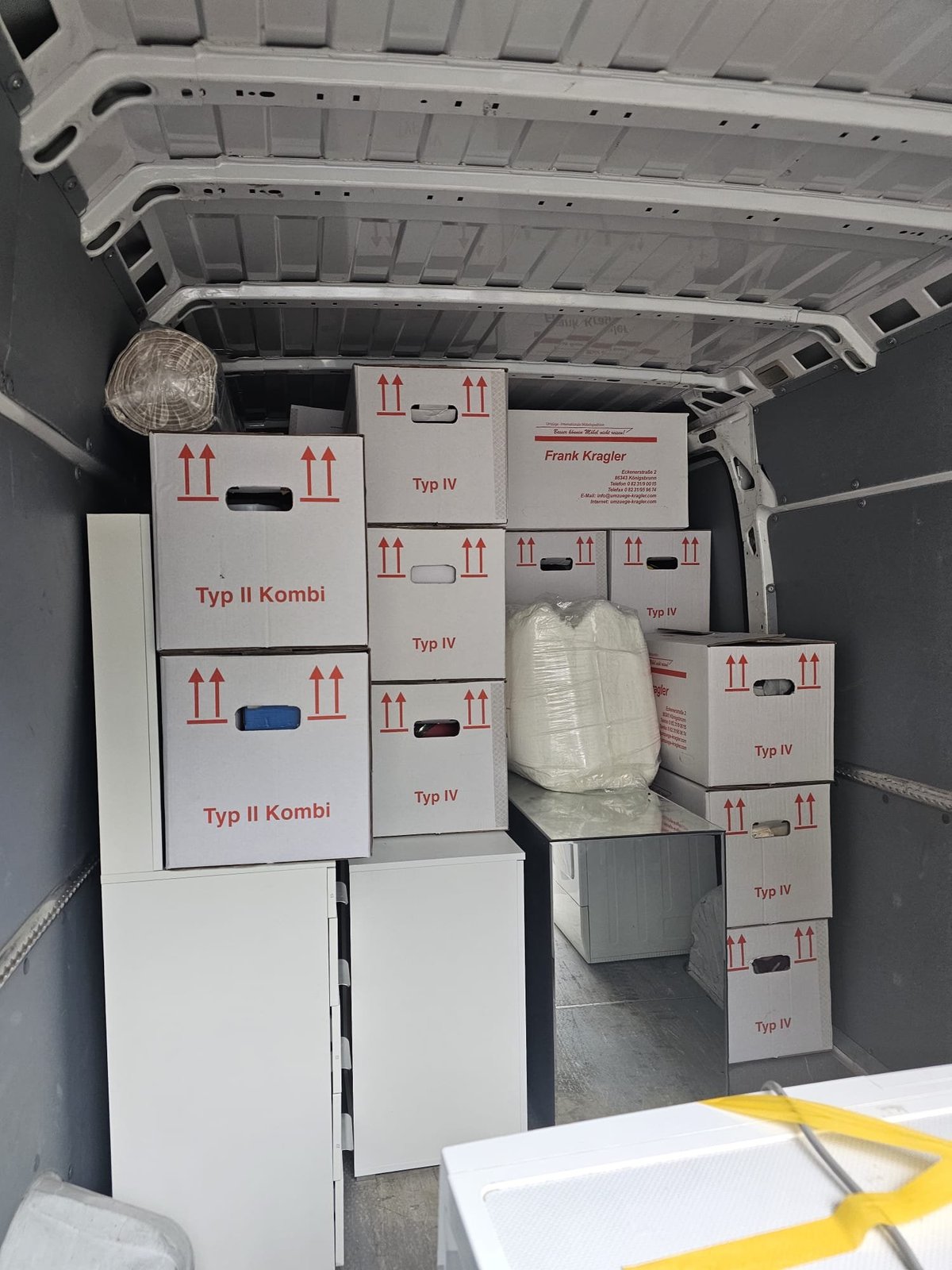 Transporter beladen mit weißen Kartons vom M☆K König Umzug — Möbeltransport Augsburg