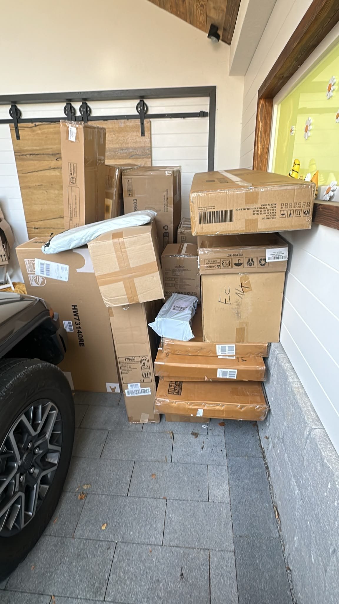 Stapel von Lieferkartons in einer Garage neben einem geparkten Auto — M☆K König Möbeltransport