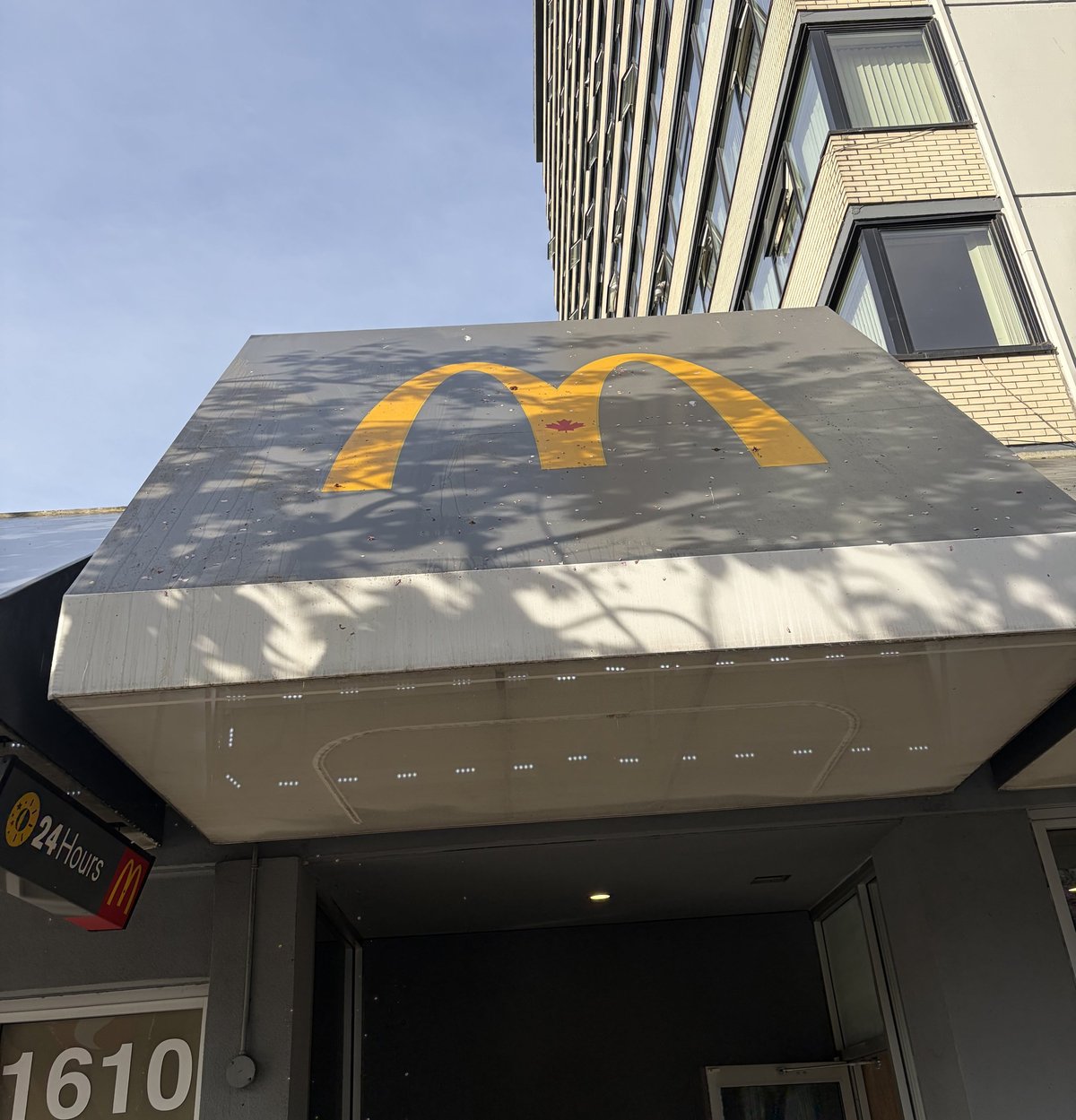 McDonalds storefront with golden arches logo on awning and modern building facade