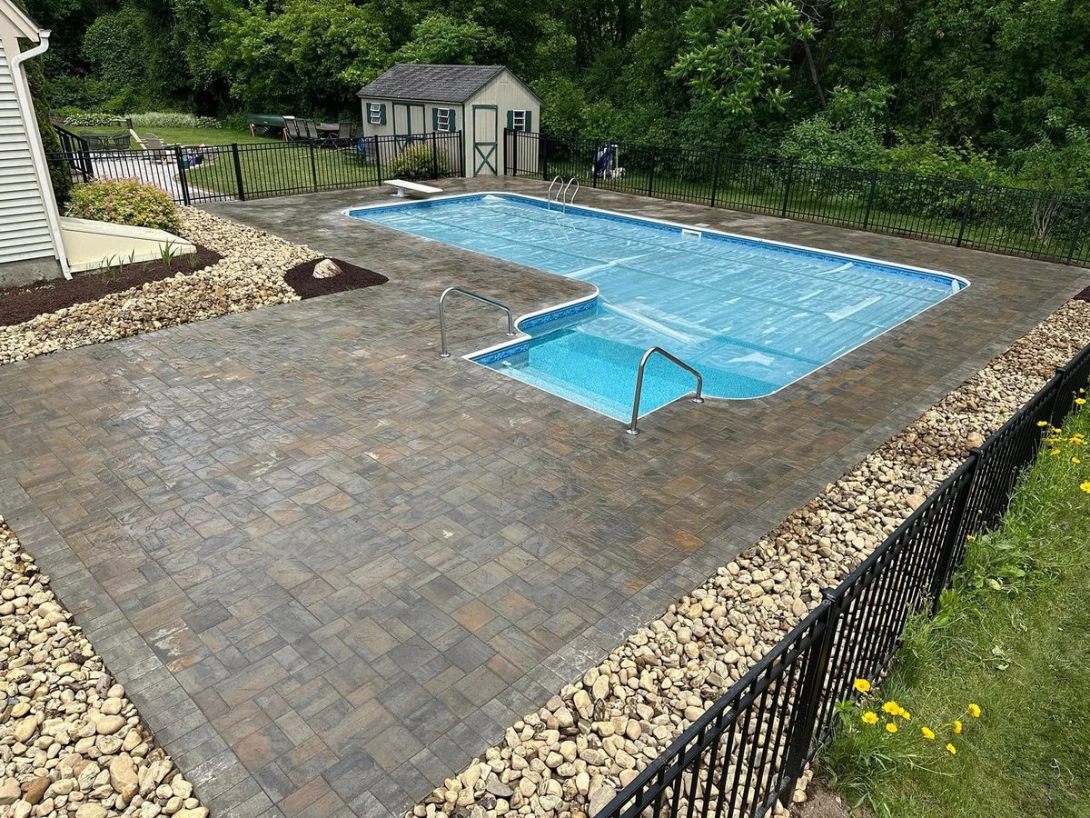 Residential backyard with stone retaining wall and paver patio
