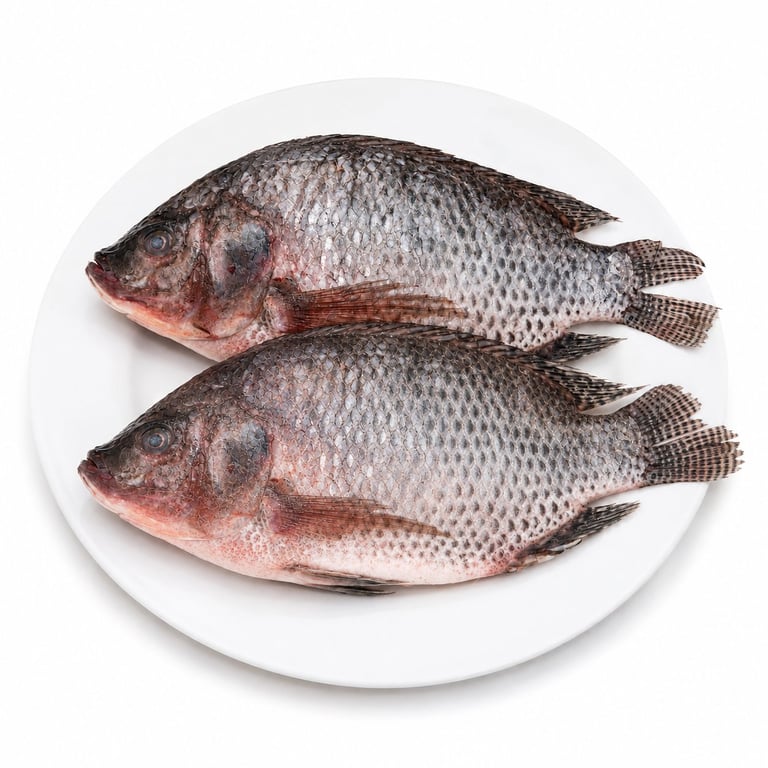 Dos mojarras frescas con escamas plateadas sobre un plato blanco