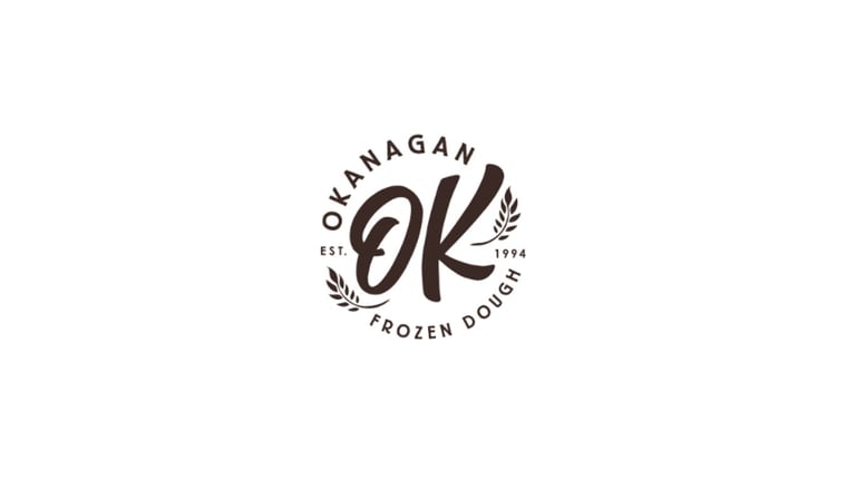 Okanagan Frozen Dough logo featuring stylized OK lettering with wheat leaf embellishments and circular text border