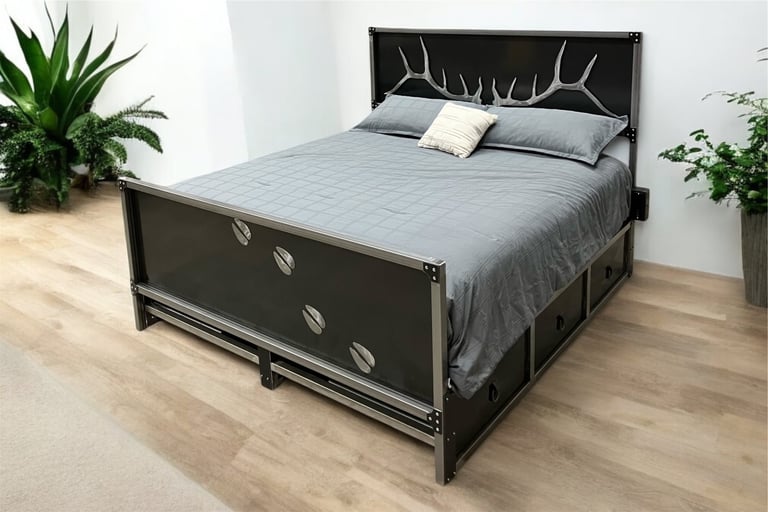 Modern black bed frame with decorative headboard and grey bedding in a bedroom with potted plants and wooden flooring
