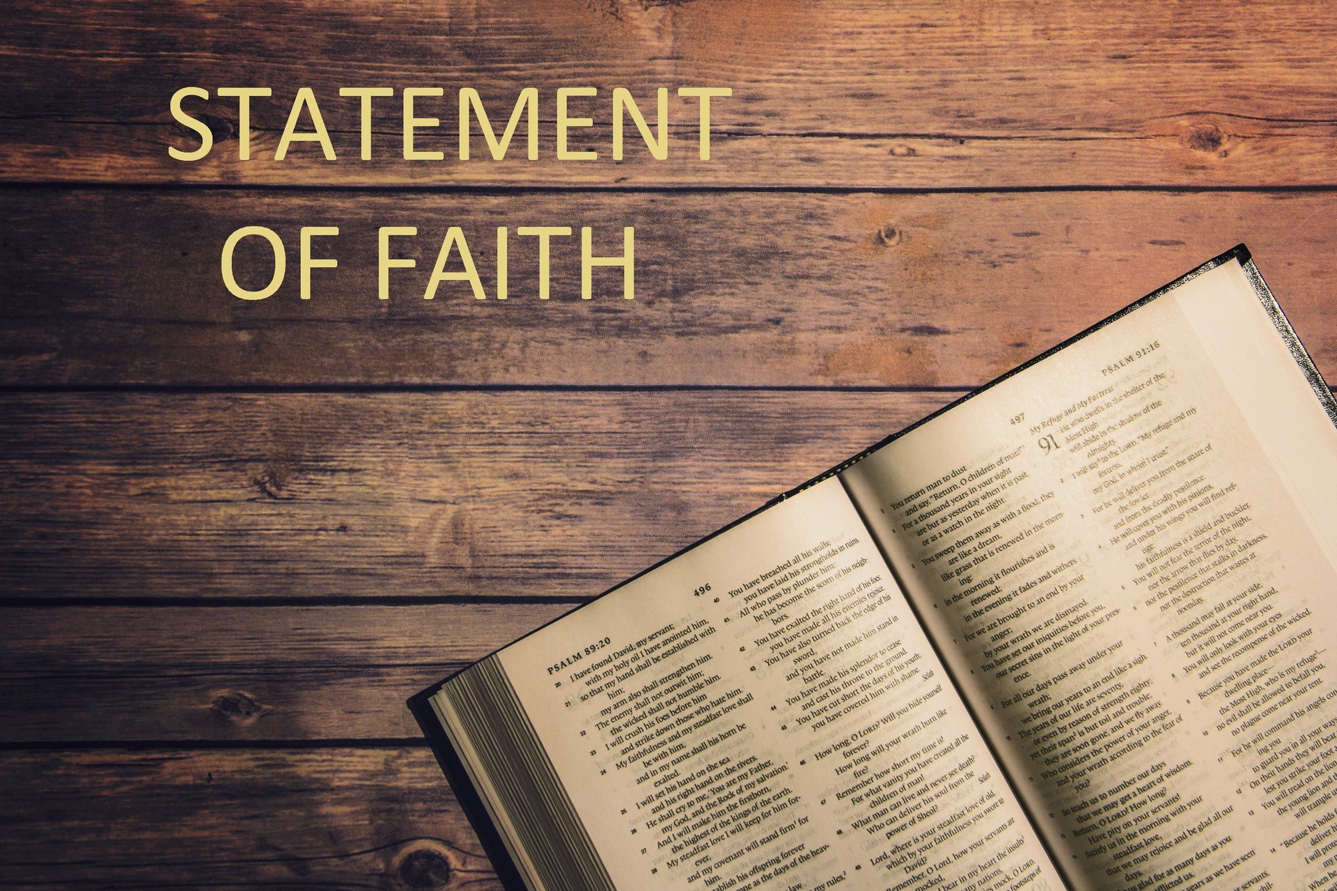 Open Bible on wooden table with Statement of Faith text overlay in gold lettering