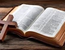 An open Bible beside a wooden cross