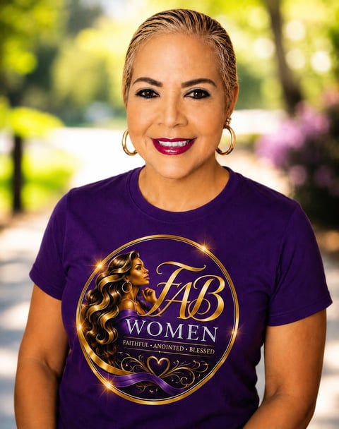Woman wearing purple FAB Women t-shirt with gold circular logo, gold hoop earrings, and bright pink lipstick, smiling outdoors with blurred garden background