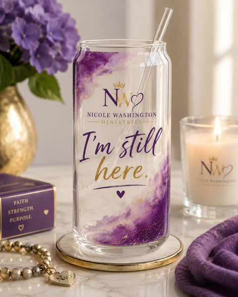 Clear glass cup with purple watercolor design and I'm still here text, displayed with matching candle and purple decor