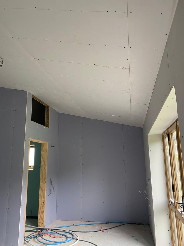 Timber stud partition room, boarded and unfinished, with door opening.