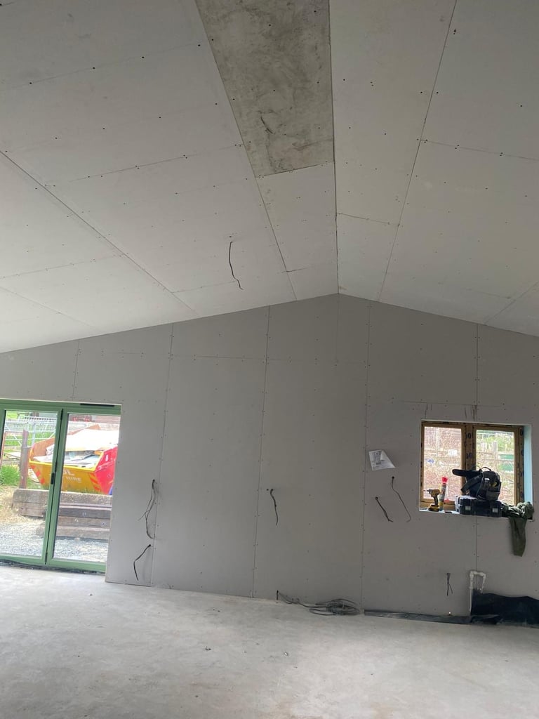 Plasterboard ceiling boarded and ready for tape and jointing, screw fixings visible ahead of finishing.