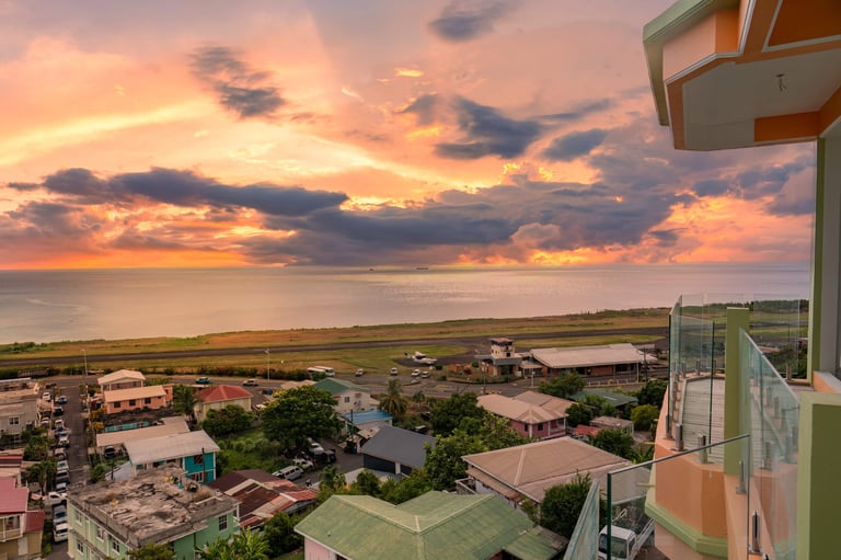 Sunset view over Canefield village with the Caribbean Sea and Canefield Airport runway, taken from a BayPort balcony