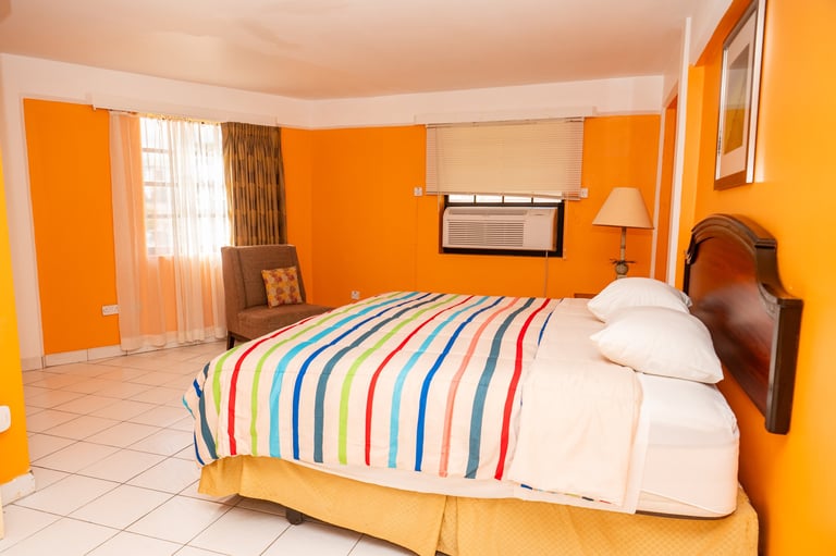 Vibrant orange and yellow bedroom with colorful striped bed