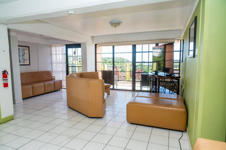 Bright modern lobby with tan leather seating, tiled flooring, and lime green accent wall at BayPort Residence Inn