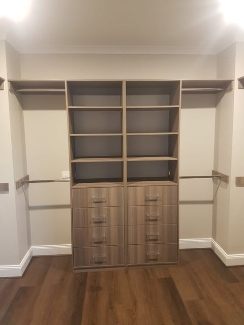 Organised custom walk-in robe with wooden drawers by The Wardrobe Guy