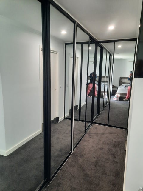 Black-framed glass wardrobe partition with hanging space by The Wardrobe Guy